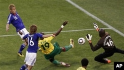 Japan's Keisuke Honda, top left, scores the opening goal against Cameroon goalkeeper Souleymanou Hamidou, right, and Cameroon's Stephane Mbia, third from left, during the World Cup group E soccer match between Japan and Cameroon at Free State Stadium in B