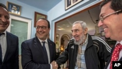 Cuba's former leader Fidel Castro, second right, shakes hands with French President Francois Hollande, while accompanied by Cuba's Foreign Minister Bruno Rodriguez, right, and an unidentified person, left, in Havana, Cuba, Monday, May 11, 2015. Hollande i