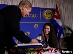 FILE - US Senator Bill Nelson (D-FL) presents a US flag to Yoani Sanchez, the best-known dissident blogger from Cuba, after she spoke at the Freedom Tower in Miami, Florida April 1, 2013.