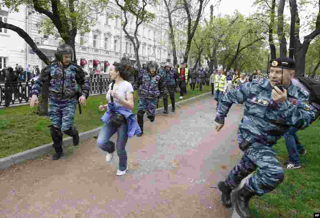 Polisi huru-hara mengejar para pendukung oposisi yang berpartisipasi dalam aksi unjuk rasa yang berlangsung tanpa izin di Moskow, Senin (7/5).