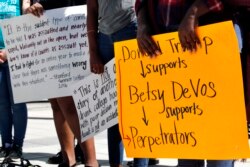 People gather to protest proposed changes to Title IX before a speech by Education Secretary Betsy DeVos, Thursday, Sept. 7, 2017, at George Mason University Arlington, Va.