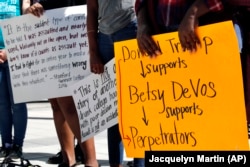 People gather to protest proposed changes to Title IX before a speech by Education Secretary Betsy DeVos, Thursday, Sept. 7, 2017, at George Mason University Arlington, Va.