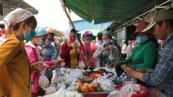 Garment workers buying lunch at a food stall outside of Propitious (Cambodia) Garment Ltd. factory in Kandal province, Cambodia, March 20, 2020. (Kann Vicheika/VOA Khmer)