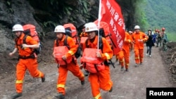 Lực lượng cứu hộ chạy qua đống đổ nát để đến các khu vực hẻo lánh trong tỉnh Tứ Xuyên, ngày 21/4/2013.