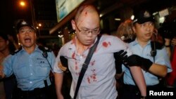 3일 중국의 홍콩 행정장관 선거안에 반대하는 반정부 시위에 참가한 한 청년이 친중 성향의 시위대 난입으로 부상을 당한 가운데, 경찰의 부축을 받고 있다.
