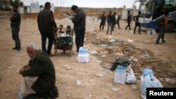이라크 군과 ISIL간 교전이 계속되고 있는 모술 서부에서 28일 주민들이 구호 식량을 기다리고 있다.