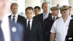 France's President Nicolas Sarkozy (C) and Defense Minister Gerard Longuet (L) leave the Percy hospital in Clamart, neat Paris after visiting French soldiers wounded in Afghanistan, July 14, 2011