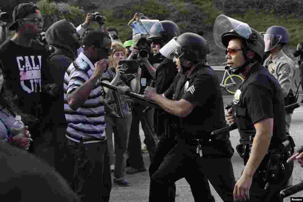 Police confront a crowd of demonstrators on the Interstate 10 freeway as they protest the acquittal of George Zimmerman in the Trayvon Martin trial, Los Angeles, California July 14, 2013.