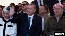 Turkey's Prime Minister Tayyip Erdogan and President of Iraqi Kurdistan Masoud Barzani (R) attend a ceremony with Erdogan's wife Emine Erdogan in Diyarbakir, Turkey, Nov. 16, 2013.