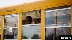 FILE - A school bus full of children heads to school in the St. Louis area. A mother is suing the school system, claiming her son is unable to attend a city charter school because he is black.