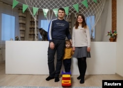 Dokter mata Alesya Rutsevich, 28 tahun, dan suaminya, Pyotr, 28, seorang programmer, bersama anak laki-laki mereka Daniil, 3 tahun, berfoto di rumah mereka dalam pekan Alesya kembali bekerja di Minsk, Belarusia, 23 Februari 2019.