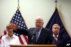 U.S. Senator John McCain, center, speaks during a press conference at the Resolute Support headquarters in Kabul, Afghanistan, July 4, 2017. Senators Elizabeth Warren, left, and Lindsey Graham are seen in the background.