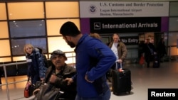 Mohanmmed (R) greets his father Jasim (C), who arrived on a flight from Doha, Qatar after U.S. President Donald Trump's executive order travel ban at Logan Airport in Boston, Massachusetts, Jan. 30, 2017. Mohammed and Jasim were reunited three hours after the flight landed, during which Jasim, a green card holder, was questioned by U.S. immigration officials.