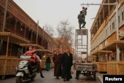 Men install a camera in a shopping street in the old town of Kashgar, Xinjiang Uighur Autonomous Region, China, March 23, 2017.