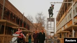 2017年3月23日工作人员在中国新疆维吾尔自治区喀什老城区购物街上安装相机。