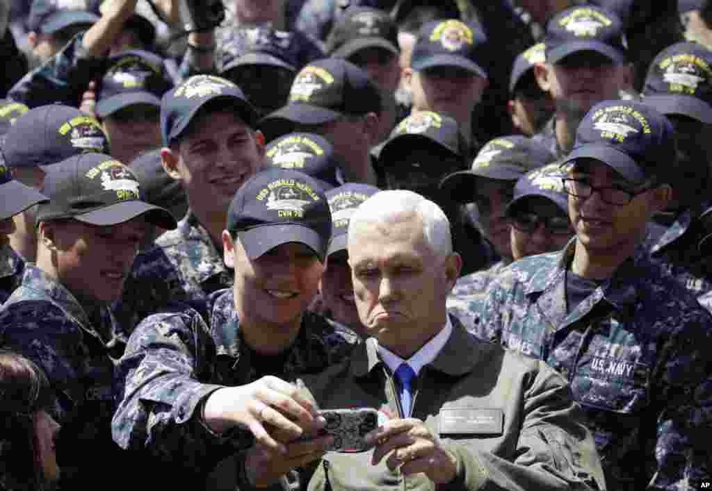 U.S. Vice President Mike Pence, center right at bottom, takes a selfie with U.S. servicemen on the flight deck of nuclear-powered aircraft carrier USS Ronald Reagan, at the Yokosuka base in Yokosuka, south of Tokyo, Japan.