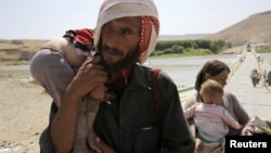 Seorang pria bersama istri dan anak-anaknya mengungsi dari wilayah konflik di kota Sinjar, Irak, melintasi perbatasan Irak-Suriah di Fishkhabour, provinsi Dohuk (Foto: dok). 