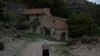 FILE - Sinforosa Sancho, 84, takes a walk in the empty village of La Estrella, Spain, May 24, 2018. For more than 30 years, Sinforosa and her husband Juan Martin Colomer lived alone in the village that once had more than 200 inhabitants.