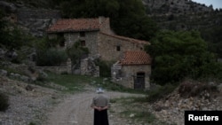 FILE - Sinforosa Sancho, 84, takes a walk in the empty village of La Estrella, Spain, May 24, 2018. For more than 30 years, Sinforosa and her husband Juan Martin Colomer lived alone in the village that once had more than 200 inhabitants.