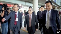 South Korea's top nuclear envoy Wi Sung-lac (C) is escorted to an entrance after arriving at the Capital International Airport in Beijing, China, September 20, 2011.