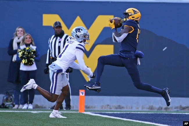 FILE - West Virginia wide receiver Sam James catches a touchdown pass while defended by Kansas State safety Josh Hayes during the first half of an NCAA college football game in Morgantown, W.Va., Saturday, Nov. 19, 2022. (AP Photo/Kathleen Batten)