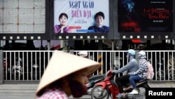 Para pengendara sepeda melintasi ruang iklan yang kosong pernah diisi poster film animasi DreamWorks "Abominable" sebelum dicopot di sebuah bioskop di Hanoi, Vietnam, 14 Oktober 2019. (Foto: Reuters)