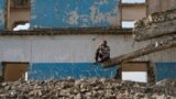 A displaced man sits on the ruins of a destroyed building outside Hammam al-Alil camp, south of Mosul, Iraq.