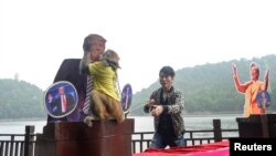 Un singe porte un tee-shirt "le roi de la prédiction" et embrasse la photo de Donald Trump, à Changsha, Chine, le 3 novembre 2016.