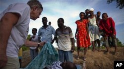 Doctor Maraykanka oo eegaya mid ka mid ah dadka ku dhintay cudurka daacuunka ee ka dhacay Haiti.
