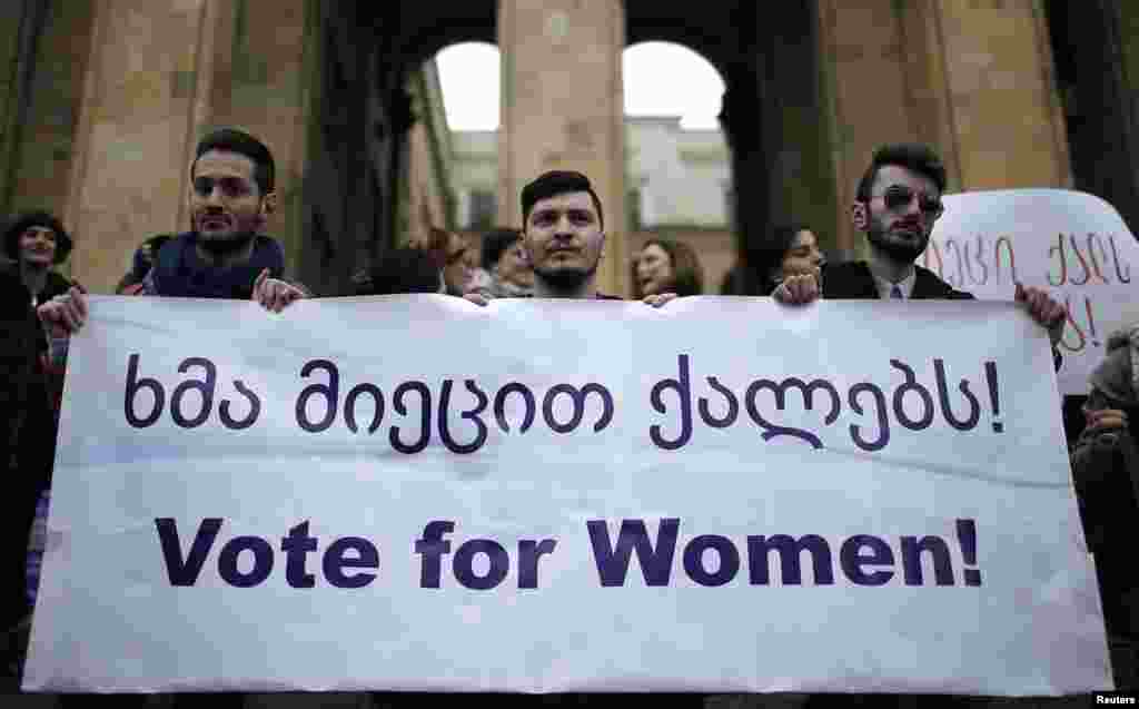 Men hold a banner during a protest demanding stronger women&#39;s political representation and engagement in parliament in front of the Parliament building on International Women&#39;s Day in Tbilisi, March 8, 2015.