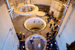 FILE - In this photo released by the Atomic Energy Organization of Iran, technicians work at the Arak heavy water reactor's secondary circuit as officials and media visit the site, near Arak., Dc. 23, 2019.