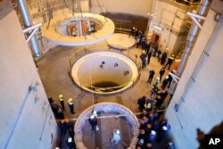 FILE - In this photo released by the Atomic Energy Organization of Iran, technicians work at the Arak heavy water reactor's secondary circuit as officials and media visit the site, near Arak., Dec. 23, 2019.