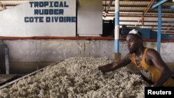 FILE - A man works at a rubber factory in Songon village, north of Abidjan, January 25, 2016. 