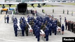 Military personnel unload a coffin with the remains of Brazilian victims who died in a plane crash in the Colombian jungle with Brazilian soccer team Chapecoense. The bodies will be flown home to Brazil, Dec. 2, 2016.