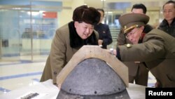 Pemimpin Korea Utara, Kim Jong Un (kiri) mengamati hulu ledak roket usai uji coba misil Korea Utara 15 Maret lalu (foto: dok).