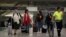 Travelers wear protective masks as a precaution against the coronavirus, at the airport in Mexico City, Mexico, Feb. 28, 2020.