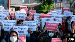Protesters hold posters in support of the National Unity Government (NUG) during a demonstration against the military coup on "Global Myanmar Spring Revolution Day" in Taunggyi, Shan state on May 2, 2021. (Photo by STR / AFP)