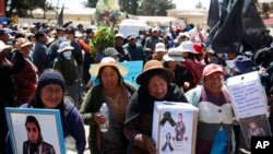 Residentes cargan ataúdes y fotos de los muertos durante un cortejo fúnebre de manifestantes asesinados durante enfrentamientos con la policía en Juliaca, Perú, el miércoles 11 de enero de 2023. 