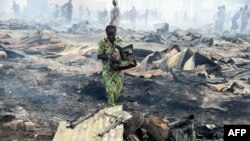 A local resident attempts to salvage a stove from the fire in the biggest Lagos wood market, Oko-Baba Sawmill, in Ebute-Metta, district of Lagos, Nigeria.