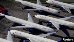FILE - Delta Air Lines passenger planes are seen parked due to flight reductions made to slow the spread of coronavirus disease (COVID-19), at Birmingham-Shuttlesworth International Airport in Birmingham, Alabama, March 25, 2020. 