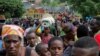 Refugees from the Democratic Republic of the Congo carry their belongings as they walk near the U.N. High Commissioner for Refugees offices in Karongi district, Rwanda, Feb. 21, 2018.