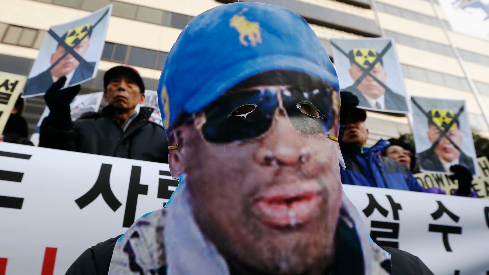 A protester wearing a mask depicting former U.S. basketball star Dennis Rodman, attends a rally in central Seoul, South Korea, Jan.8, 2014, denouncing Rodman's visit to North Korea and North Korean leader Kim Jong Un on Kim's birthday. 