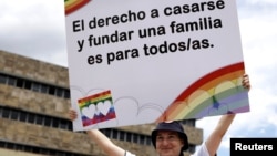 Un activista sostiene un cartel durante una manifestación de la comunidad LGBT frente a la Corte Suprema de Justicia en San José, Costa Rica, el 4 de agosto de 2018.