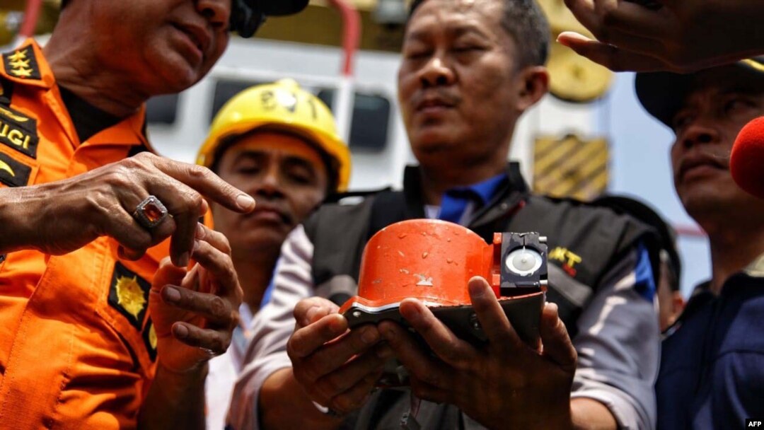 Para petugas tampak menunjukkan sebagian dari kotak hitam Lion Air no penerbangan JT610 yang bernasib naas, yaitu perekam data penerbangan (FDR), yang berhasil diangkat dari Laut Jawa, dalam operasi pencarian di perairan lepas pantai Karawang tanggal 1 November 2018 (foto: Pradita Utama/Detikcom/AFP)