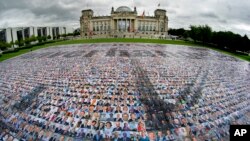 Portraits of politicans are placed in front of the Reichstag building, host of the German federal parliament Bundestag, by the &#39;#unverhandelbar&#39; (#non-negotiable) campaign group in Berlin, Germany, to protest against human rights at Europe&#39;s external borders.