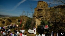 Devotees listen to mass accompanied by the three women known as ''La Mondidas'', during a religious pilgrimage in honor of Saint Bartholomew in the small village of Sarnago, northern Spain, Aug. 26, 2018.