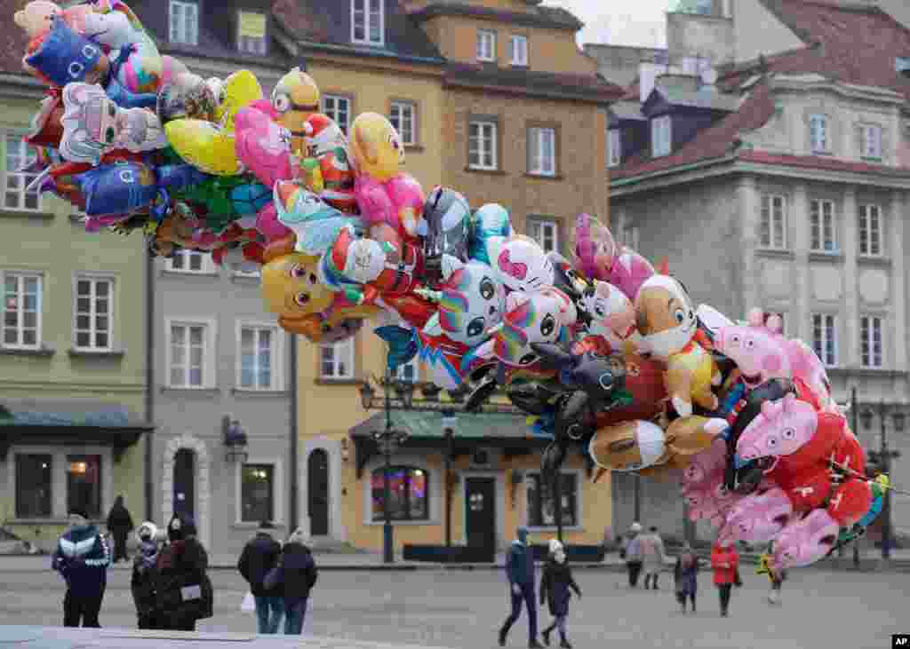 새해를 하루 앞둔 폴란드 바르샤바의 캐슬스퀘어 광장에서 풍선 판매원이 손님을 기다리고 있다.