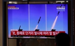 People watch a TV screen airing reports about North Korea's firing missiles with file images of missiles at the Seoul Railway Station in Seoul, South Korea, April 14, 2020.