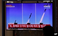 FILE - People watch a TV screen airing reports about North Korea's firing missiles with file images of missiles at the Seoul Railway Station in Seoul, South Korea, April 14, 2020.