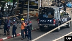 FILE - Police arrest people as part of a crackdown on demonstrations against the military coup, in Yangon, Myanmar, Feb. 27, 2021. Journalists are now being increasingly targeted for detentions. 